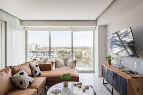 a living room with a couch and a large window at Luxury Condo On The Marina in Puerto Vallarta