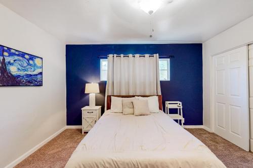 a bedroom with a bed and a blue wall at Enchanting Escape in Phoenix
