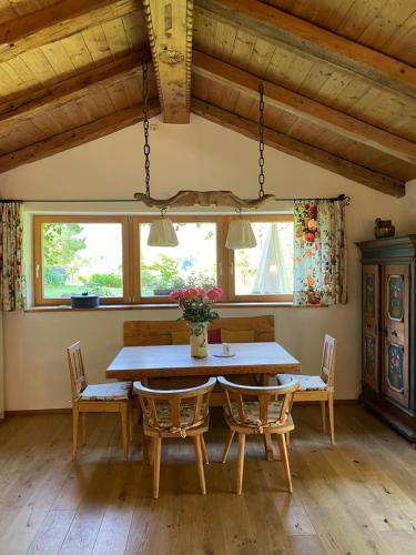 a dining room table with two chairs and a vase of flowers at Zuhaus Schernfeichten in Kitzbühel