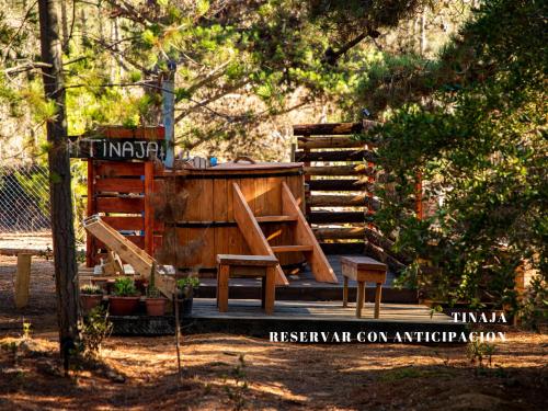a wooden playground with a bench and a chair at Cabañitas del Bosque in Algarrobo