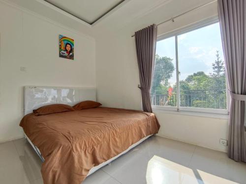 a bedroom with a bed and a large window at Villa Cisarua RJS in Brujul