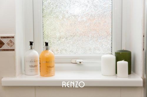 a window sill with two bottles and candles on it at Beautiful 2-bed Home in Nottingham by Renzo, Free Wi-Fi, Ideal for Contractors in Nottingham