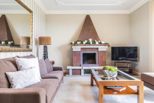 a living room with a couch and a fireplace at Casa Olimpo by Homie in Estreito de Câmara de Lobos