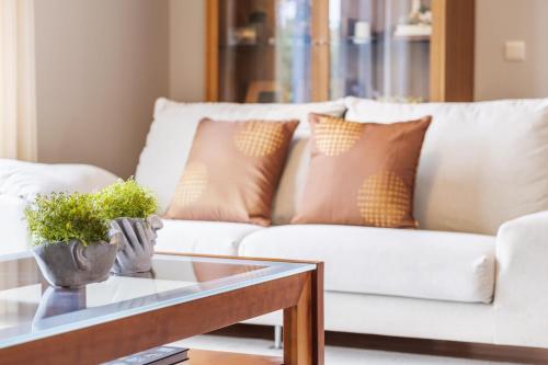 a living room with a white couch with pillows at Casa Olimpo by Homie in Estreito de Câmara de Lobos