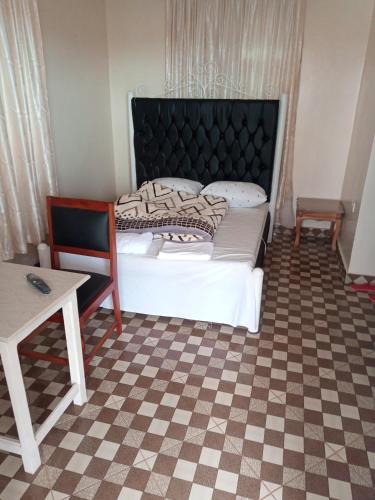 ein Schlafzimmer mit einem großen Bett und einem Tisch in der Unterkunft VOI HIGHWAY BNB in Voi