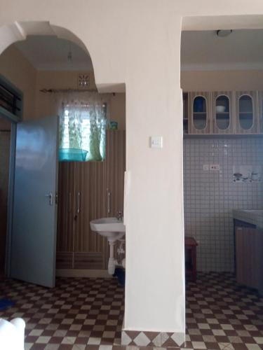 a bathroom with a sink and a mirror and a toilet at VOI HIGHWAY BNB in Voi