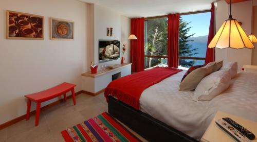 a bedroom with a bed and a large window at Luxury Lake Views Apartments By Apartments Bariloche in San Carlos de Bariloche