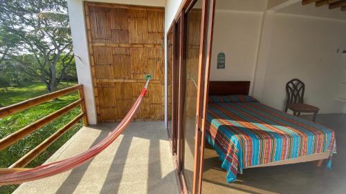 a bedroom with a hammock in a house at Hosteria Guachapeli in Las Tunas