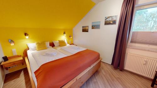 ペルツァーハケンにあるNeuKlosterhof App. 26のベッドルーム1室(黄色い壁の大型ベッド1台、窓付)
