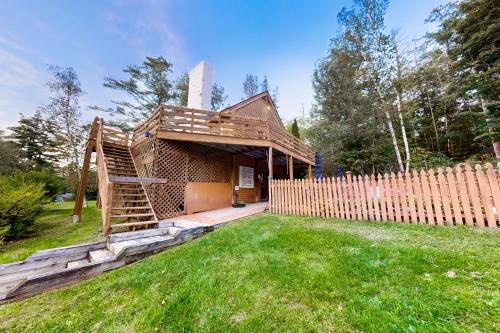 a wooden house with a wooden staircase in a yard at Birch Landing #1 in Plymouth