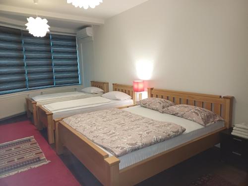 a bedroom with two beds and a window at Hollywood Motel in Podlugovi