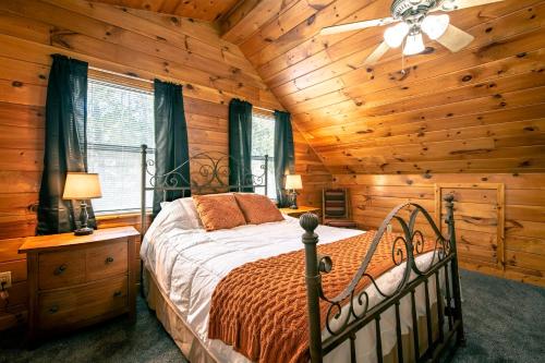 1 dormitorio con 1 cama en una cabaña de madera en Southern Grace, en Pigeon Forge