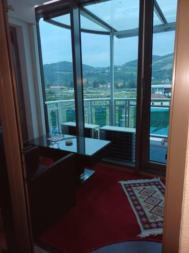 a room with a table and a large window at Hollywood Motel in Podlugovi