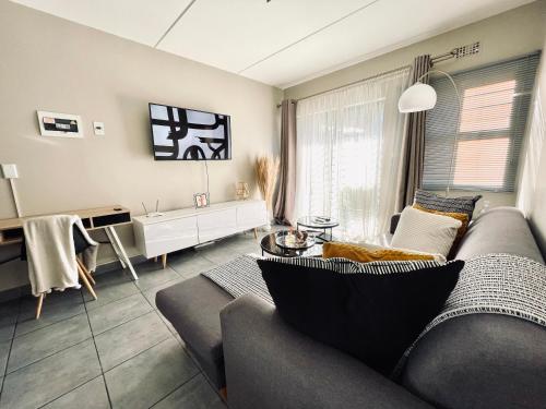 a living room with a couch and a table at Central and peaceful 2-bedroom Apt #ZonaHomes in Midrand