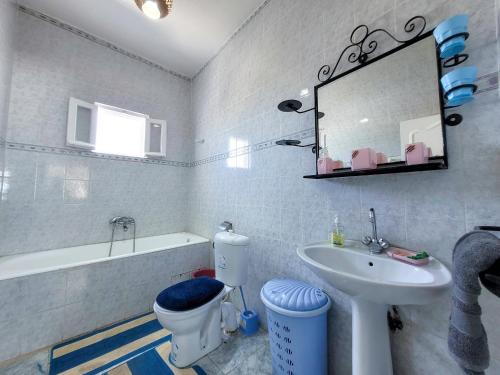 a bathroom with a sink and a toilet and a mirror at Yassmine in Djerba