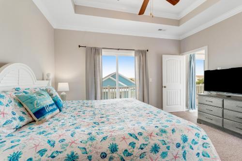 a bedroom with a large bed and a television at Glimmering Shell Hideaway in Holden Beach
