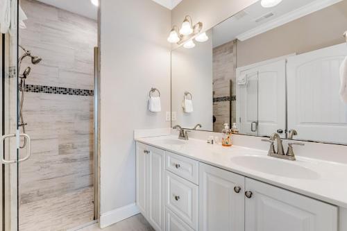 a white bathroom with a sink and a shower at Glimmering Shell Hideaway in Holden Beach