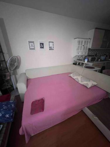 ein kleines Zimmer mit einer rosa Decke auf einem Bett in der Unterkunft BAHCELIEVLER Grandbazaar,spicebazaartram 10 min,metrobus15min in Istanbul