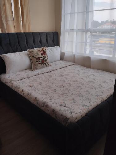 uma cama num quarto com uma grande janela em TajHomes em Eldoret
