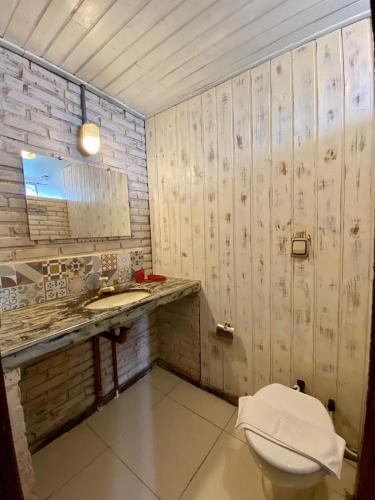 a bathroom with a toilet and a sink at Pousada Vale das Flores in Nova Friburgo