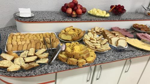 a buffet filled with different types of bread and pastries at Hotel Rota 282 in São Miguel dʼOeste