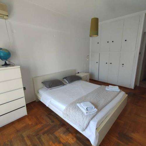 a bedroom with a large white bed and a dresser at CENTRAL ATHENS APARTMENT in Athens