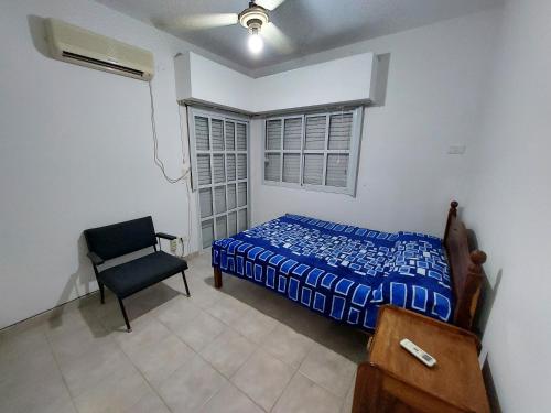 a bedroom with a bed and a chair and a window at Departamento temporario céntrico in Corrientes