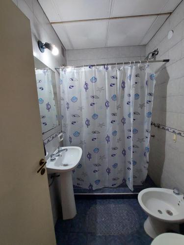 a bathroom with a sink and a shower curtain at Departamento temporario céntrico in Corrientes