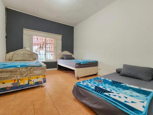 een slaapkamer met 2 bedden en een raam bij Villa Cisarua Dongkris in Brujul