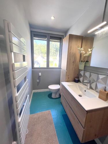 une salle de bain avec un lavabo blanc et des toilettes dans l'établissement Appartement charmant au cœur de Nonancourt, jardin privé, à Saint-Germain-sur-Avre