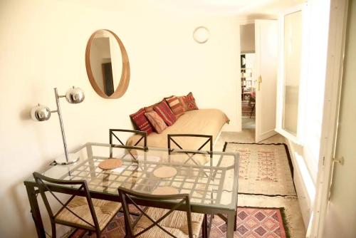 un salon avec une table en verre et un canapé dans l'établissement Appartement vue sur les toits - Saint-Germain-des-Prés, à Paris