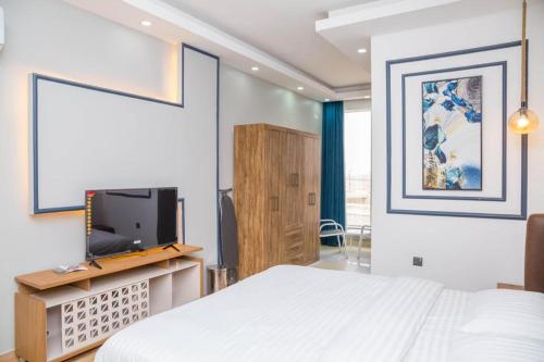 um quarto com uma cama e uma televisão de ecrã plano em Itten Plaza Hotel 2 em Salalah