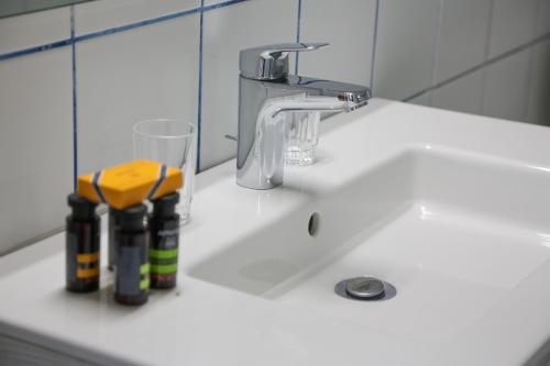 un fregadero blanco con un grifo y un vaso encima en Stylianos House 1, en Leonidio