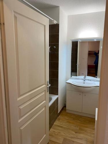une salle de bain avec un lavabo et des toilettes et une porte dans l'établissement Résidence Étoile Orion - Appartement au pied des pistes, à Orcières