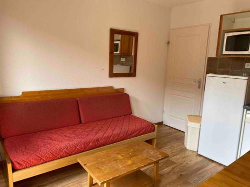 - un salon avec un canapé rouge et un réfrigérateur dans l'établissement Résidence Étoile Orion - Appartement au pied des pistes, à Orcières