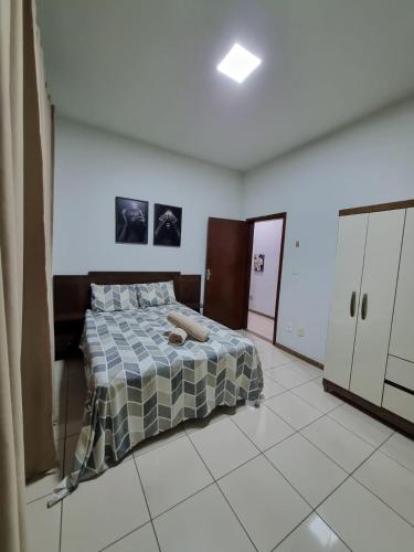 um quarto com uma cama com um cobertor em Casa inteira Ipatinga em Ipatinga