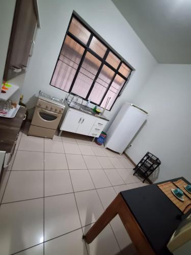 a kitchen with a large window and a white floor at Casa inteira Ipatinga in Ipatinga
