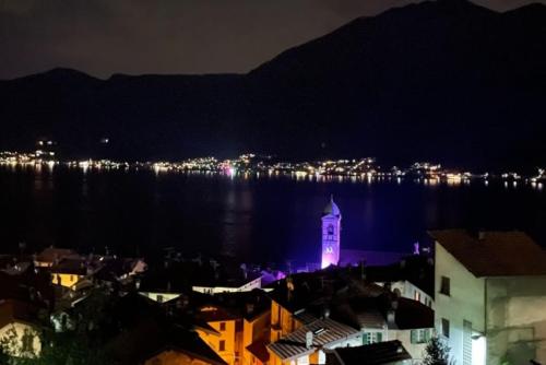 a city with a clock tower in the water at night at La casa sulla collina - apt. 2 in Colonno