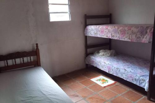 Kleines Zimmer mit 2 Etagenbetten und einem Teppich in der Unterkunft Casa p descanso em Arembepe in Arembepe