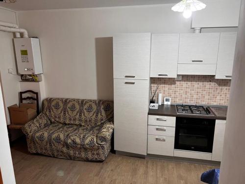 uma sala de estar com um sofá e uma cozinha em Aguzzi beb em Rieti