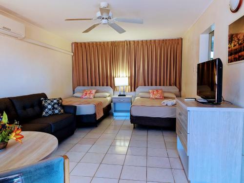 a hotel room with two beds and a couch at Sasaki Apartments in Palm-Eagle Beach