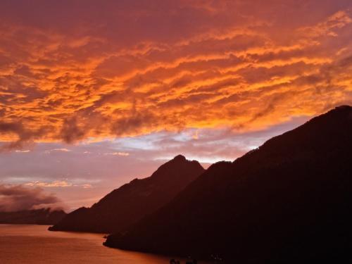 a sunset over the mountains and the water with at Traumhafte Villa Seelisberg in Seelisberg