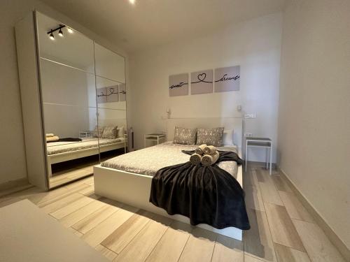 a bedroom with a bed and a large mirror at Cotillo Luna en centro, 1 min de la playa, cocina completa y WIFI in Cotillo