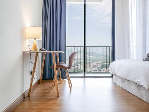a bedroom with a desk and a bed and a window at Beacon Executive Suite by Uptrend Home Management in George Town