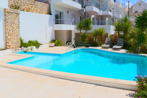 a swimming pool in front of a villa at Ericeira (S. Lourenco) Apartment in Ribamar