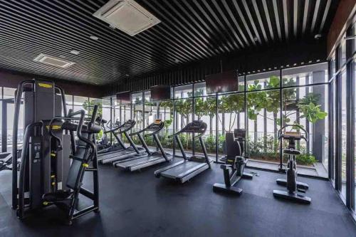 a gym with a row of treadmills and ellipticals at Beacon Executive Suite by Uptrend Home Management in George Town