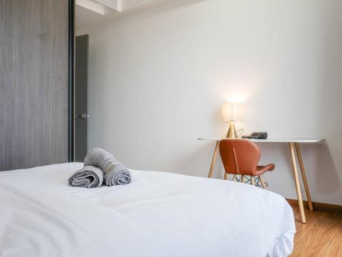 a bedroom with a bed and a desk and a chair at Beacon Executive Suite by Uptrend Home Management in George Town