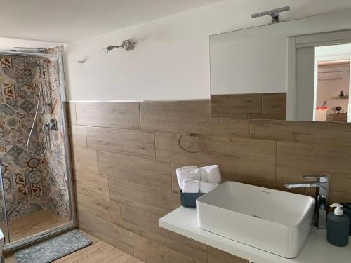 ein Badezimmer mit einem weißen Waschbecken und einer Dusche in der Unterkunft Orto siculo house-3 in Catania