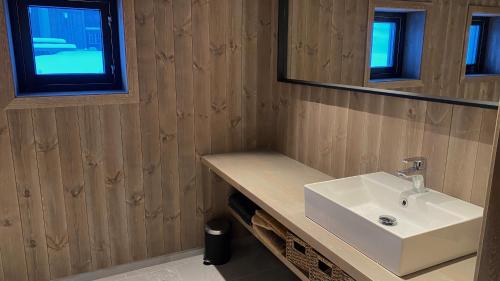a bathroom with a white sink and a mirror at Budalstølen-ny og flott hytte-sentral beliggenhet in Geilo