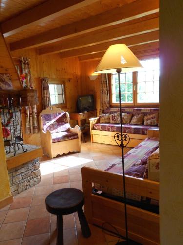 un salon avec une lampe, un canapé et une télévision dans l'établissement La Ferme Des Favrays, à Notre-Dame-de-Bellecombe